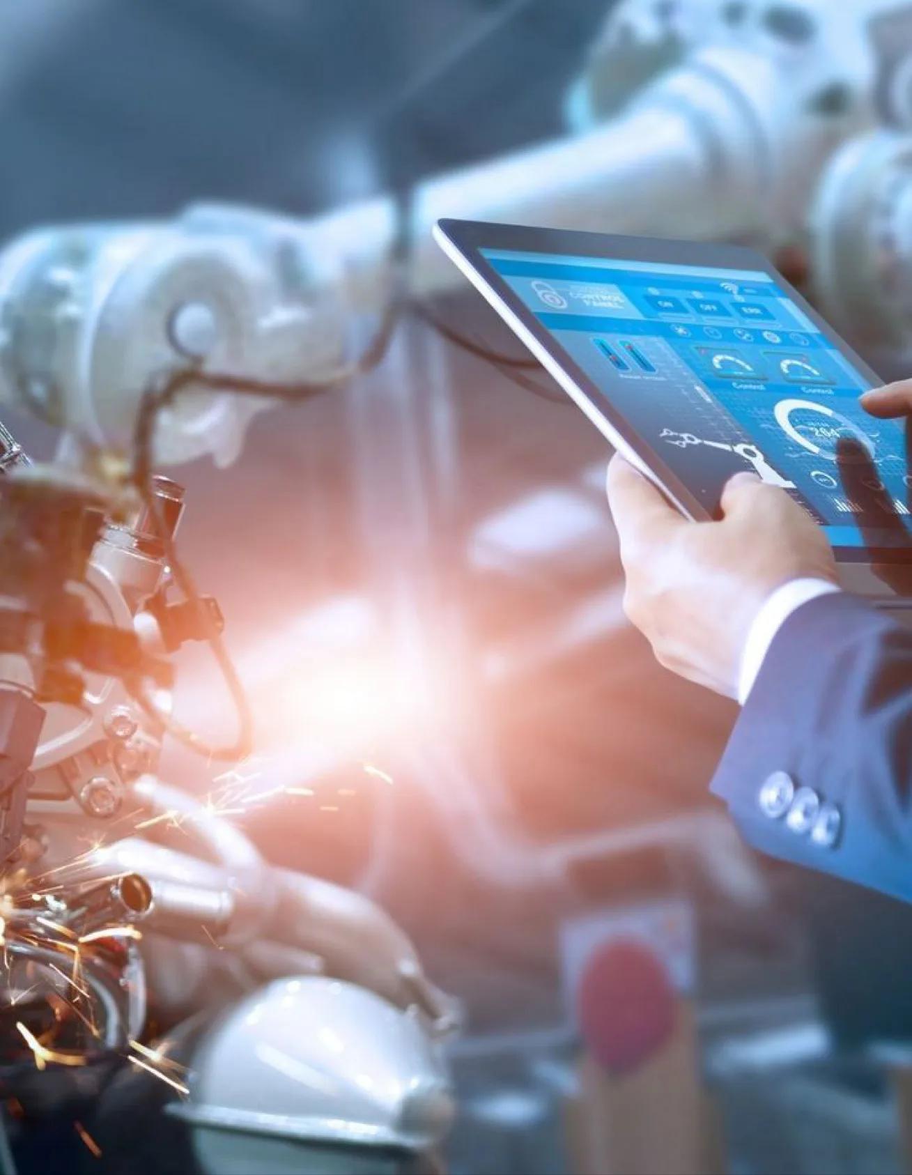 Factory worker monitoring production on a tablet